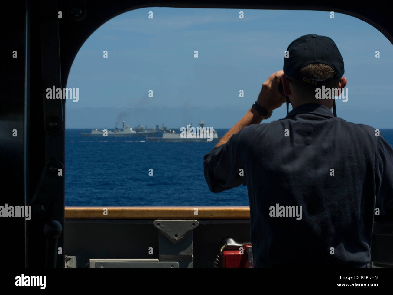 160712-N-OL837-083 OCEANO PACIFICO (12 luglio 2016) le visite-missili cruiser USS Princeton (CG 59) conning officer, alfiere di Nathan Bailey, da Chicago, osserva le punte di manovra cinese con navi della marina militare guidato-missile frigate Hengshui (572), guidata-missile destroyer Xian (153) e nave rifornimento Gaoyouhu (966), durante il cerchio del Pacifico 2016. Venti-sei nazioni, più di 40 navi e sottomarini, più di 200 aerei, e 25.000 personale partecipano RIMPAC dal 30 giugno al 4 agosto, in e intorno alle Isole Hawaii e la California del Sud. Il più grande del mondo international mari Foto Stock