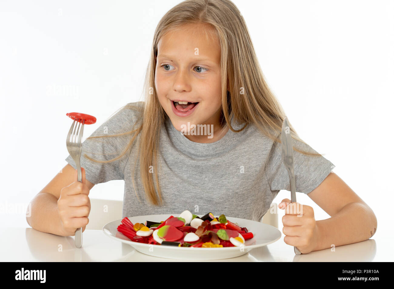 Funny Girl felice con la piastra di candy lollipop lollies felice bambina mangiare grandi zucchero candito lollies kid mangiare dolci. bambino sorpreso con la caramella. iso Foto Stock