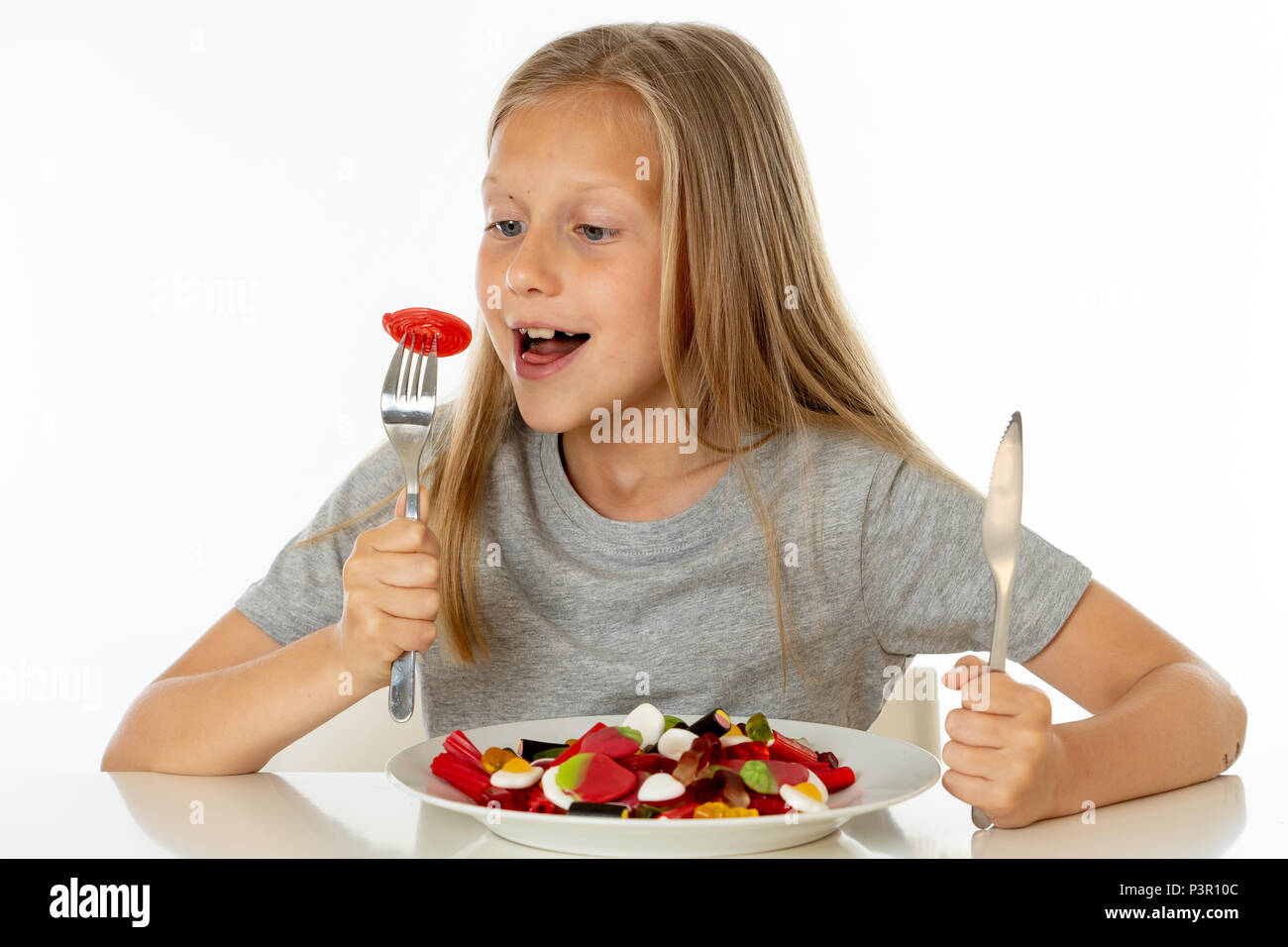 Funny Girl felice con la piastra di candy lollipop lollies felice bambina mangiare grandi zucchero candito lollies kid mangiare dolci. bambino sorpreso con la caramella. iso Foto Stock