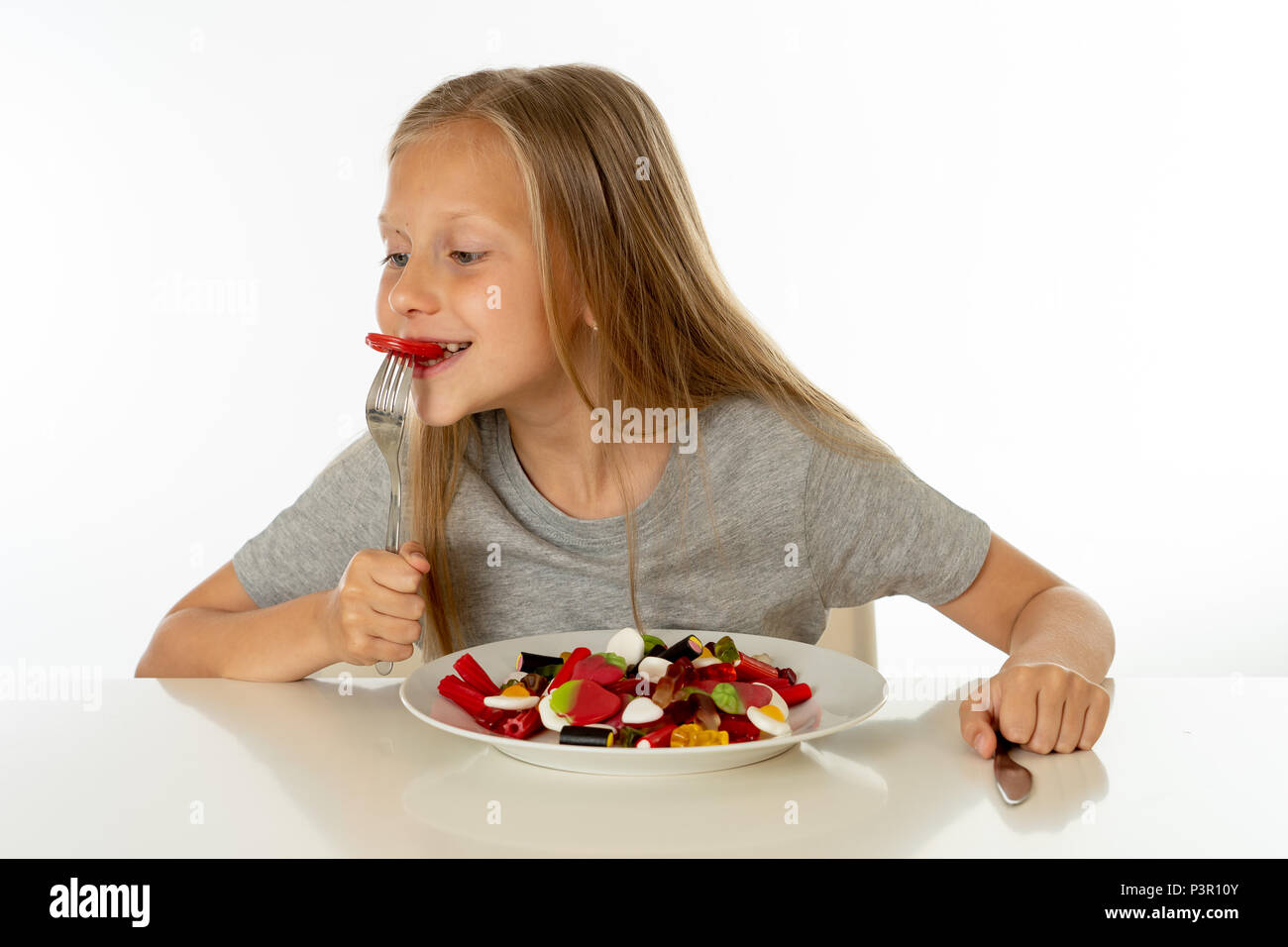 Funny Girl felice con la piastra di candy lollipop lollies felice bambina mangiare grandi zucchero candito lollies kid mangiare dolci. bambino sorpreso con la caramella. iso Foto Stock