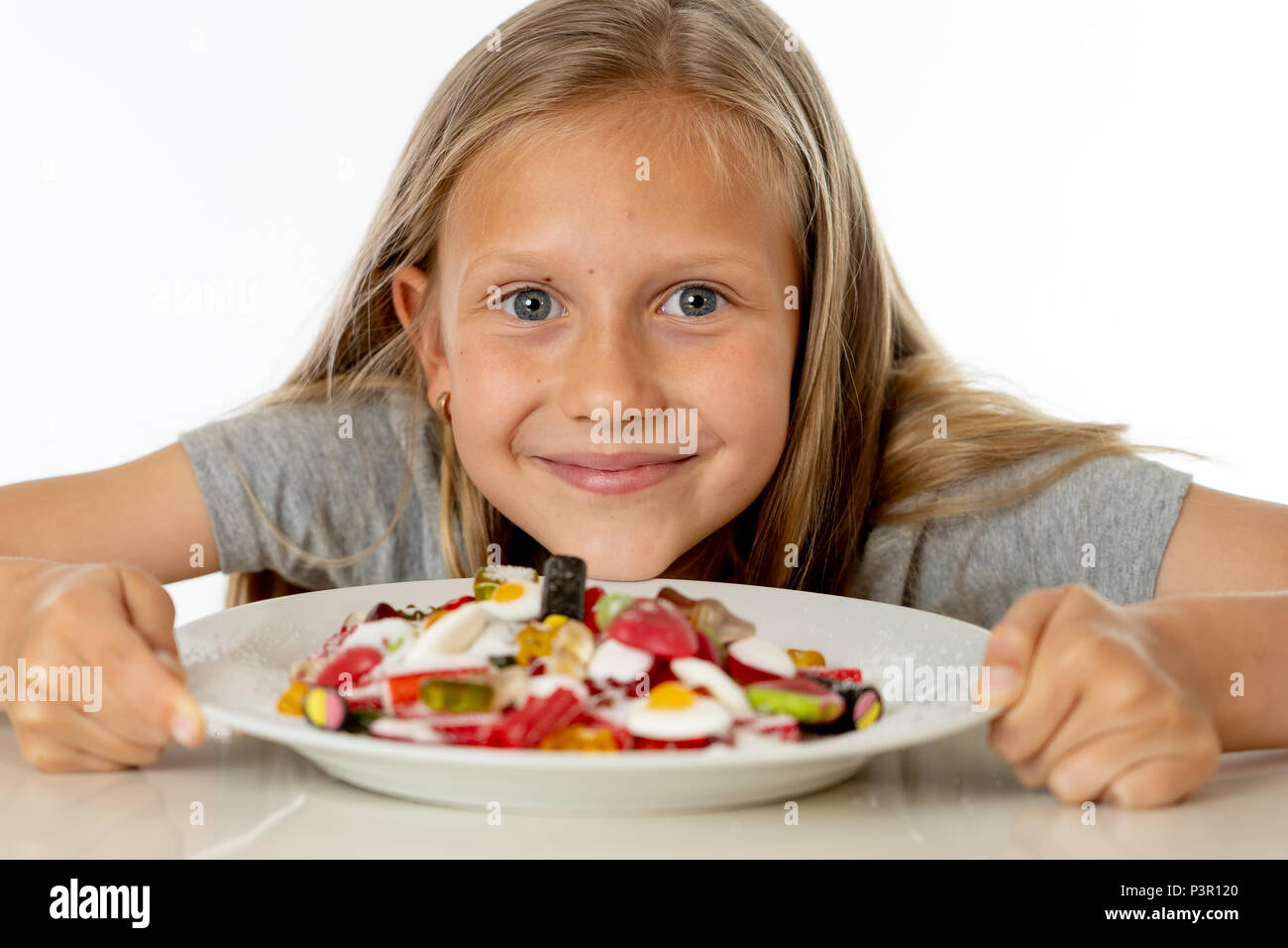 Funny Girl felice con la piastra di candy lollipop lollies felice bambina mangiare grandi zucchero candito lollies kid mangiare dolci. bambino sorpreso con la caramella. iso Foto Stock