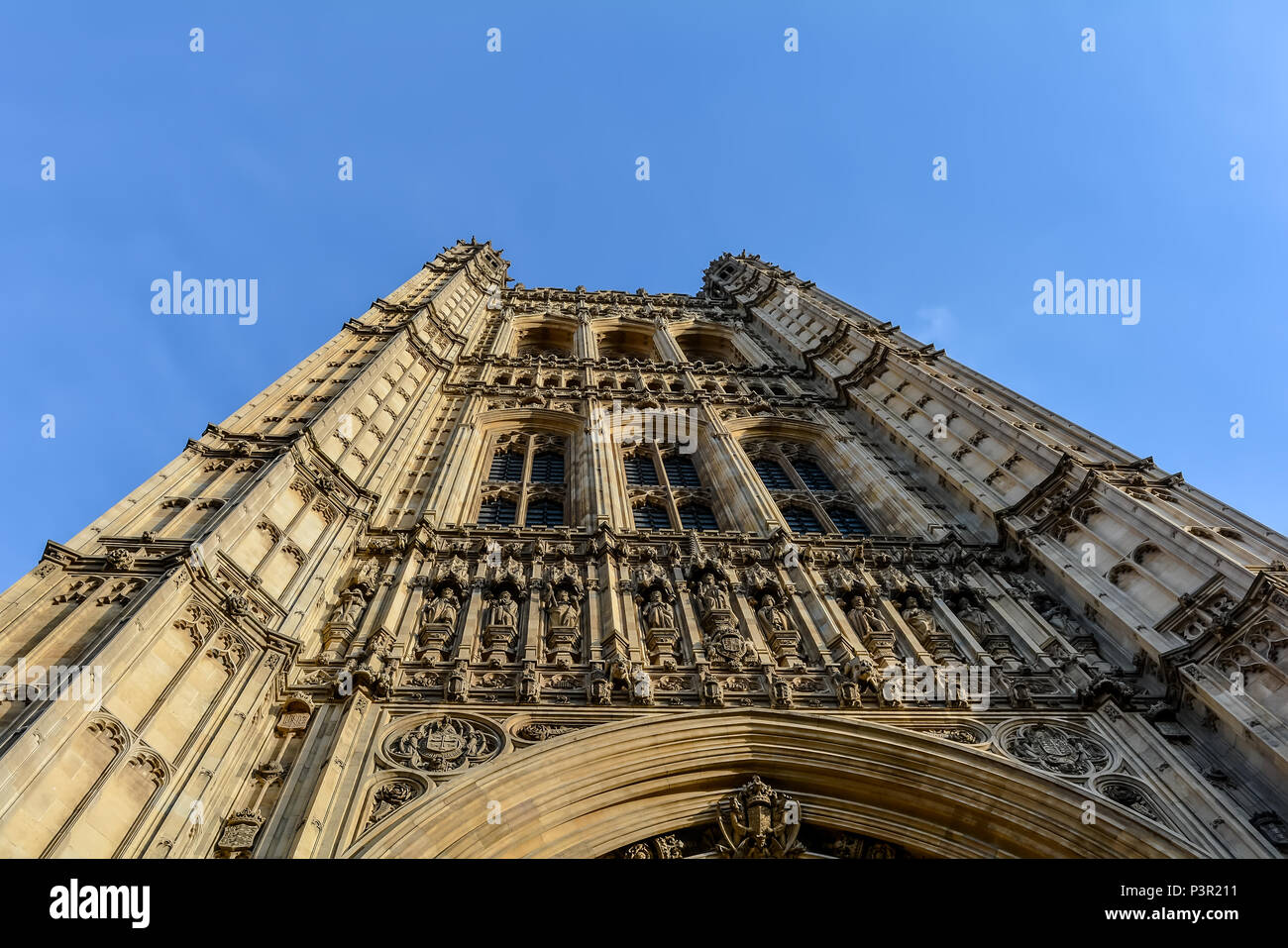Una vista del neo-gotico Victoria Torre del Palazzo di Westminster dal basso angolo contro il cielo blu Foto Stock