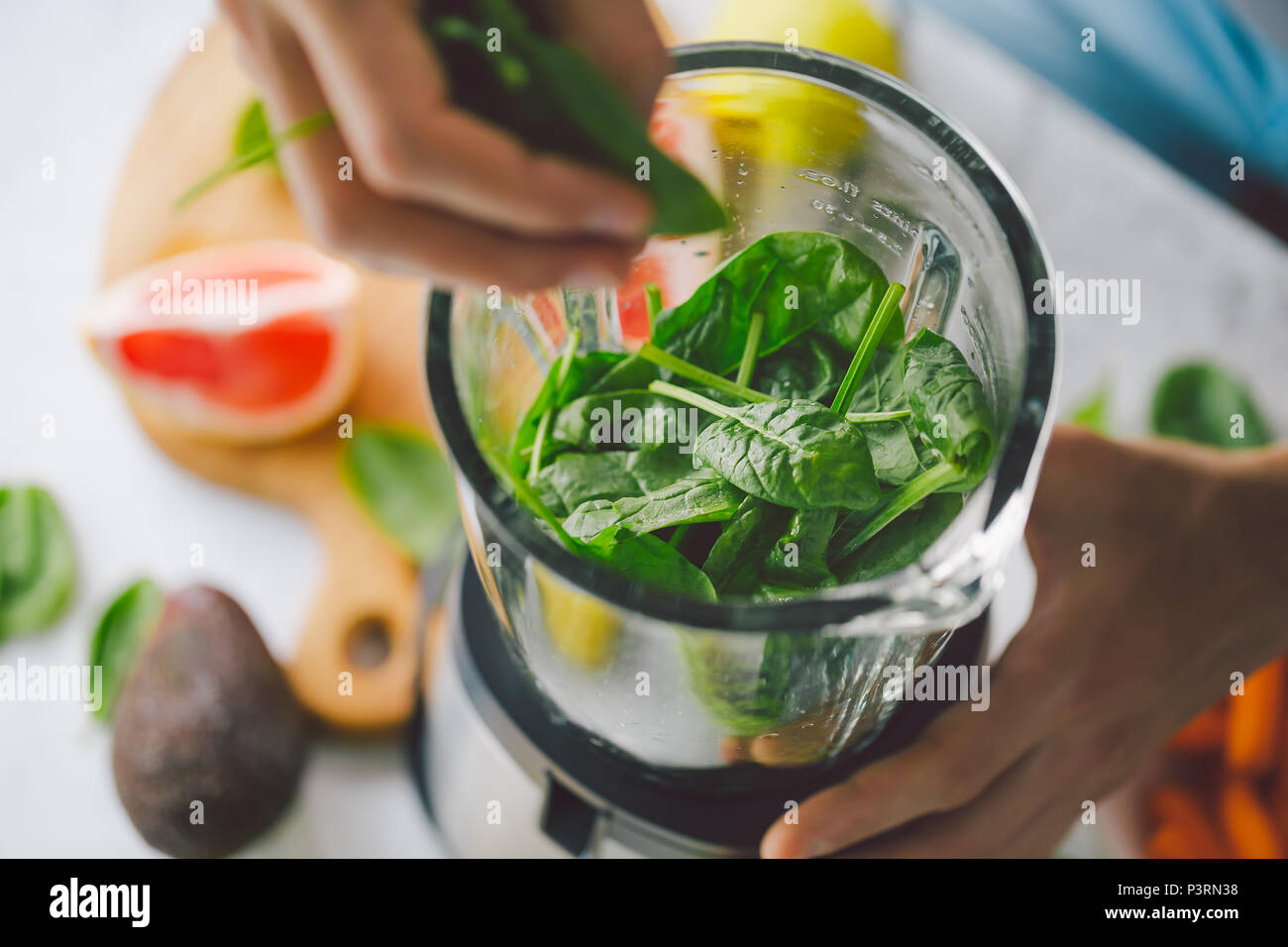 L'uomo Cottura sana detox smoothie con frutta fresca e verde di spinaci. Stile di vita concetto detox Foto Stock
