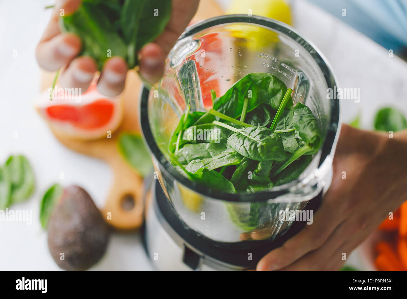 L'uomo Cottura sana detox smoothie con frutta fresca e verde di spinaci. Stile di vita concetto detox Foto Stock