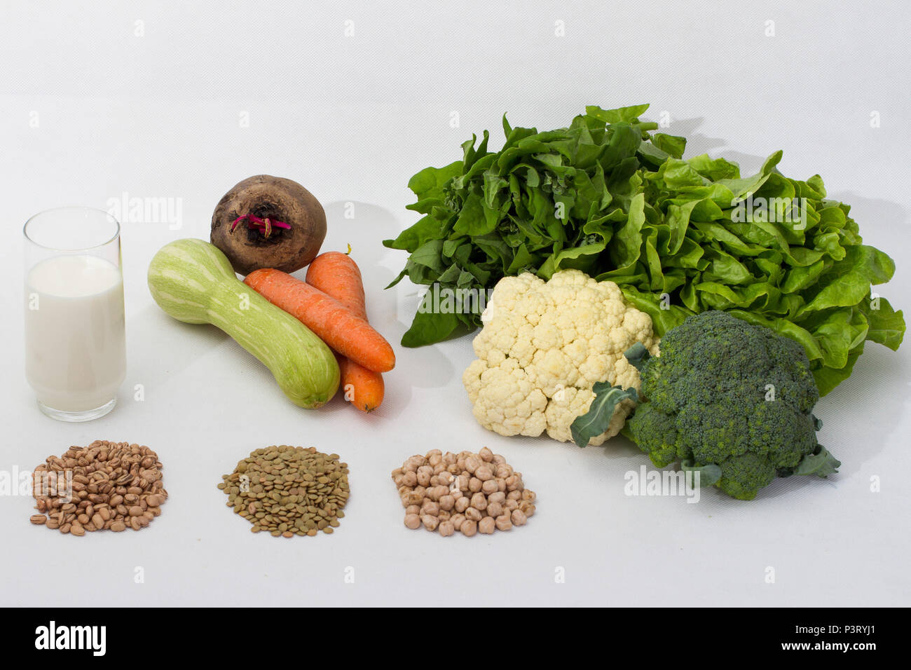 SÃO PAULO, SP - 15.10.2015: COMPOSIÇÃO FOTOGRÁFICA COM ALIMENTOS - Fotografia com os seguintes elementos: leite, lentilha, grão de bico, grãos de feijão, alface, espinafre, couve-flor, brócolis, cenoura, abobrinha, vagem, beterraba. (Foto: Ana Druzian / Fotoarena) Foto Stock