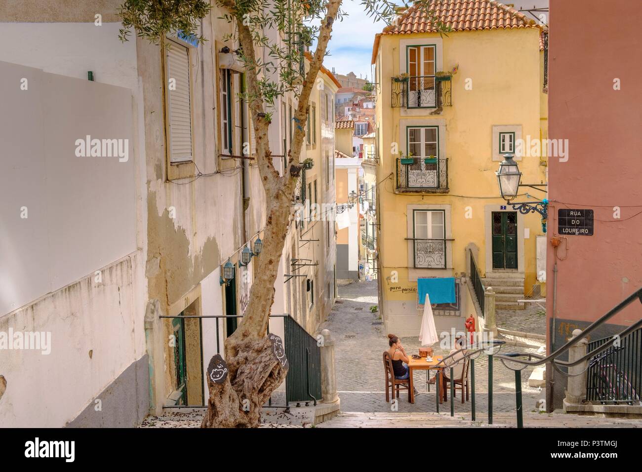 Stradine del quartiere di Alfama con la donna rilassante, Lisbona, Portogallo Foto Stock