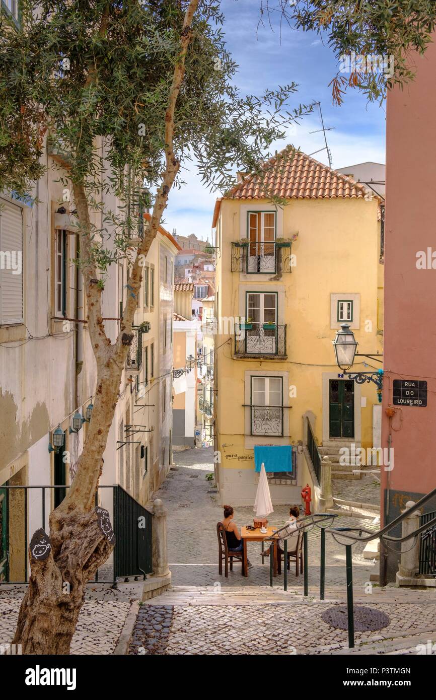 Stradine del quartiere di Alfama con la donna rilassante, Lisbona, Portogallo Foto Stock