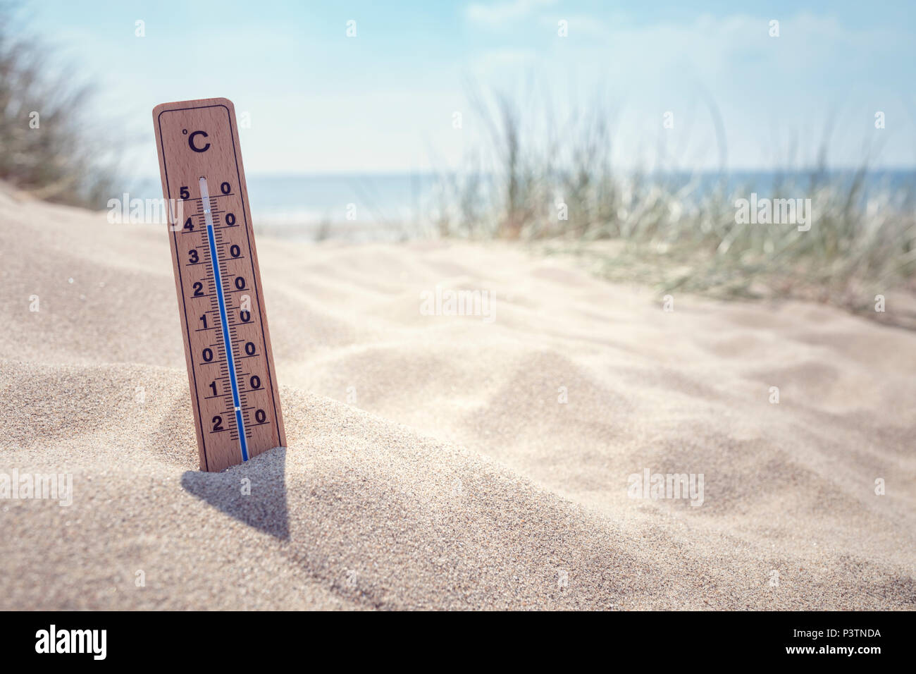 Termometro sulla spiaggia che mostra alta temperatura sullo sfondo Foto Stock