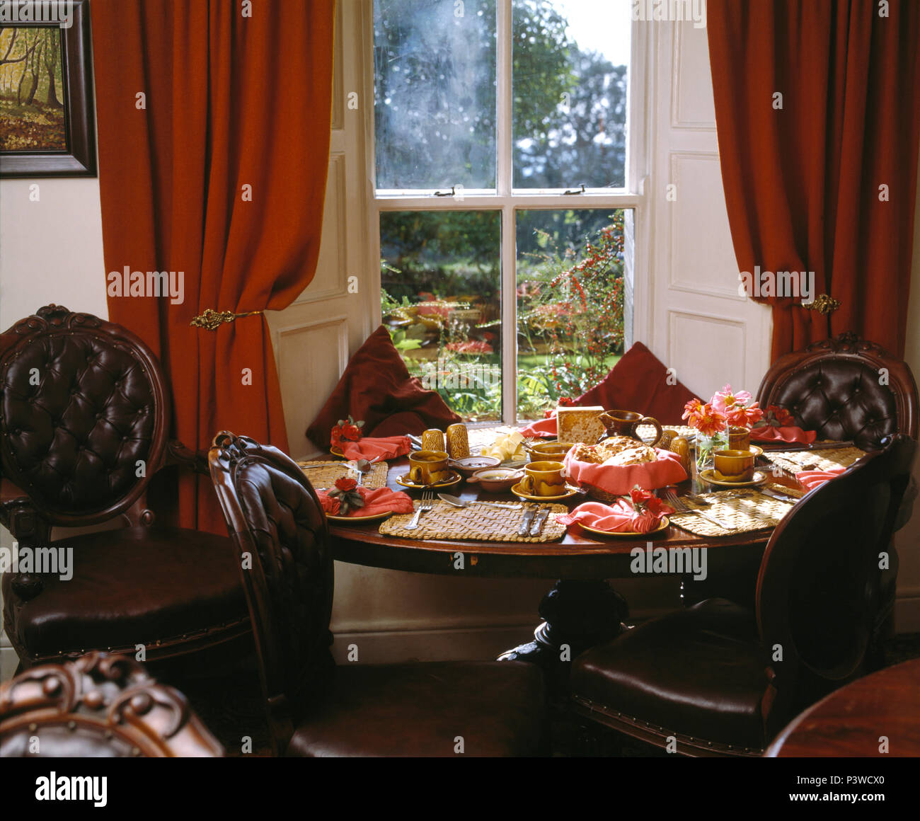 Pulsante stile vittoriano-back sedie in pelle a tavola nella parte  anteriore del vetro con tende rosse in stile vittoriano sala da pranzo Foto  stock - Alamy