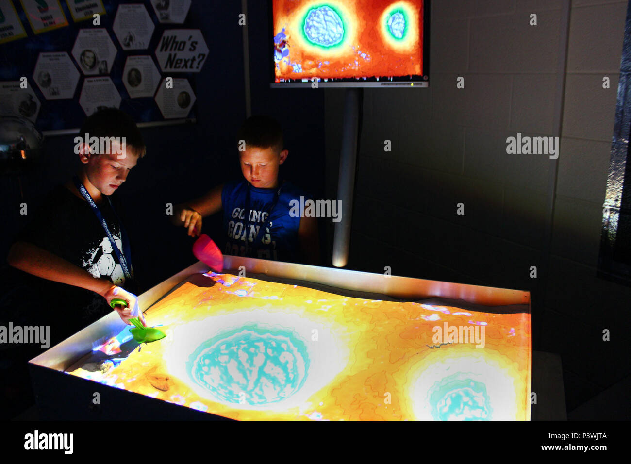 Colin Frye e Anderson Darby spostare la sabbia intorno a un'augmented reality sandbox mentre frequentano un corso di una settimana lo stelo e base camp ospitato da STARBASE Martinsburg, 29 luglio al 167° Airlift Wing. La sandbox di AR, il nuovissimo strumento di Martinsburg STARBASE classroom, consente agli utenti di creare modelli di topografia mediante sagomatura vera sabbia, che viene poi aumentata in tempo reale da un colore di elevazione mappa topografica delle linee di contorno e acqua simulato. Foto Stock