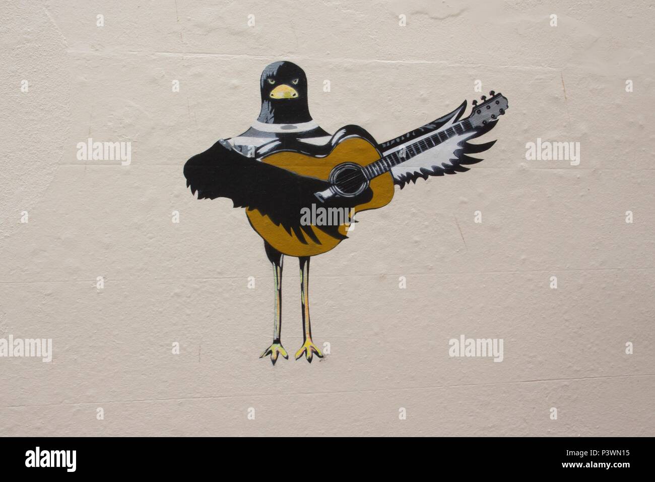 Arte di strada illustrazione di un uccello Oystercatcher di suonare una chitarra al di fuori Oystercatchers cafe in Teignmouth, South Devon Foto Stock