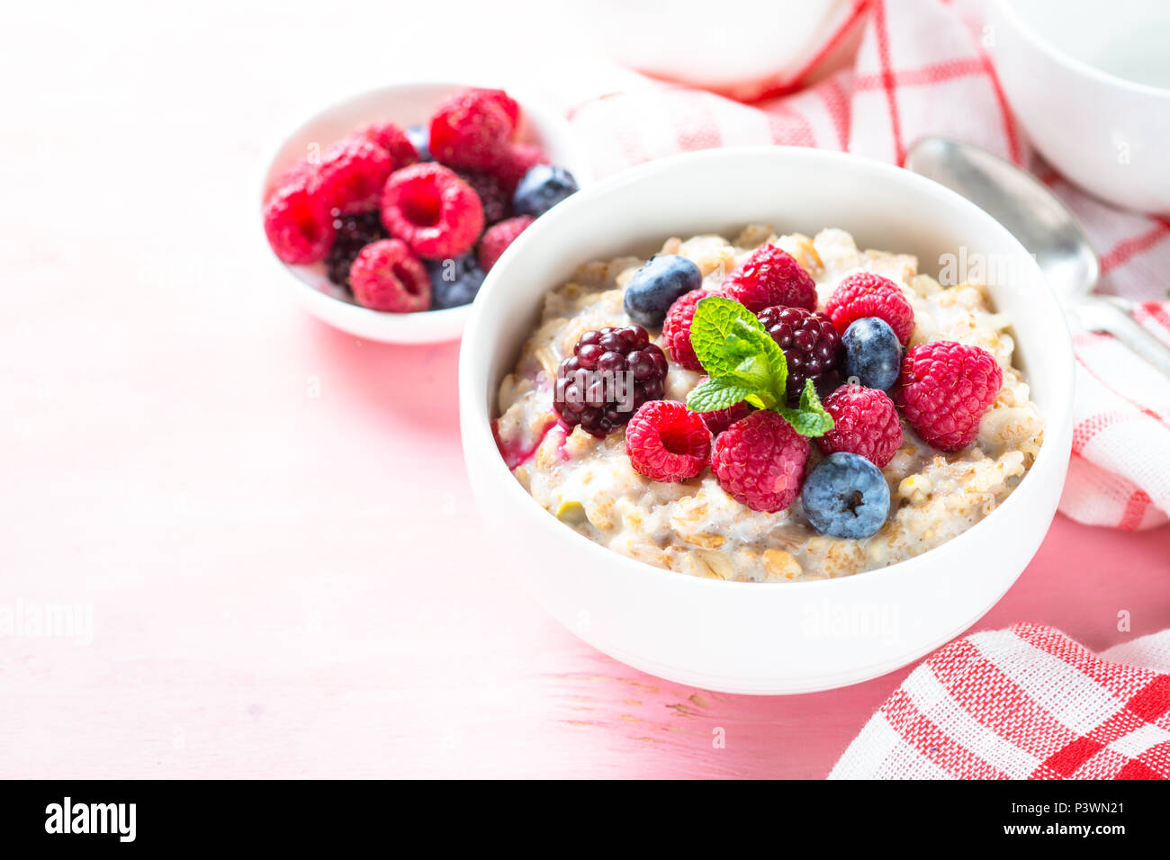 Una sana prima colazione. Farina di avena porridge con latte e frutti di  bosco in rosa Foto stock - Alamy