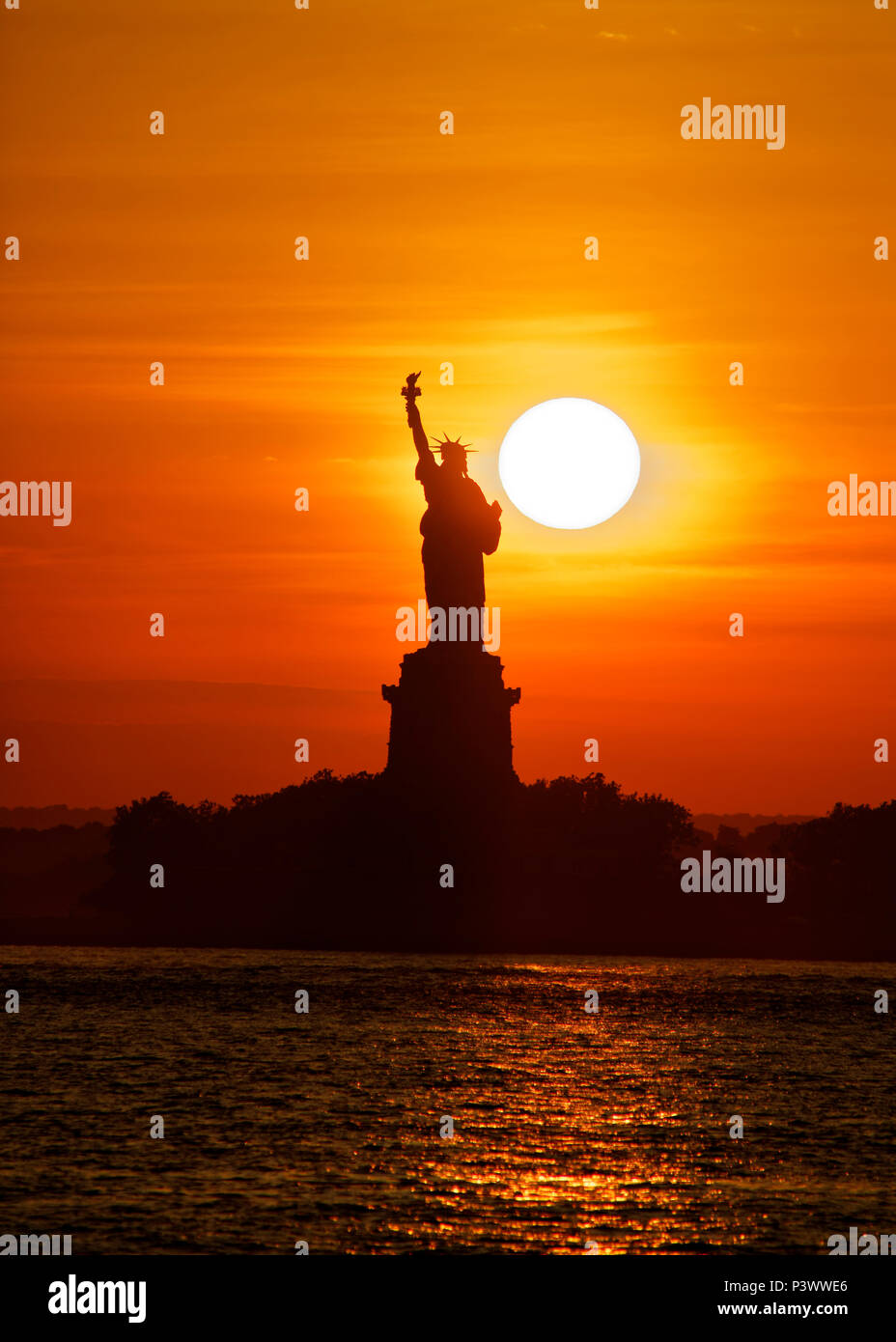 Statua della Libertà al tramonto con il sole direttamente dietro di esso, il che accade una volta l'anno Foto Stock