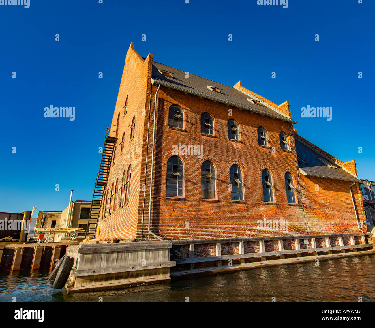 Vista in edificio tradizionale in mattoni rossi dal canale in Copenhagen, Danimarca Foto Stock