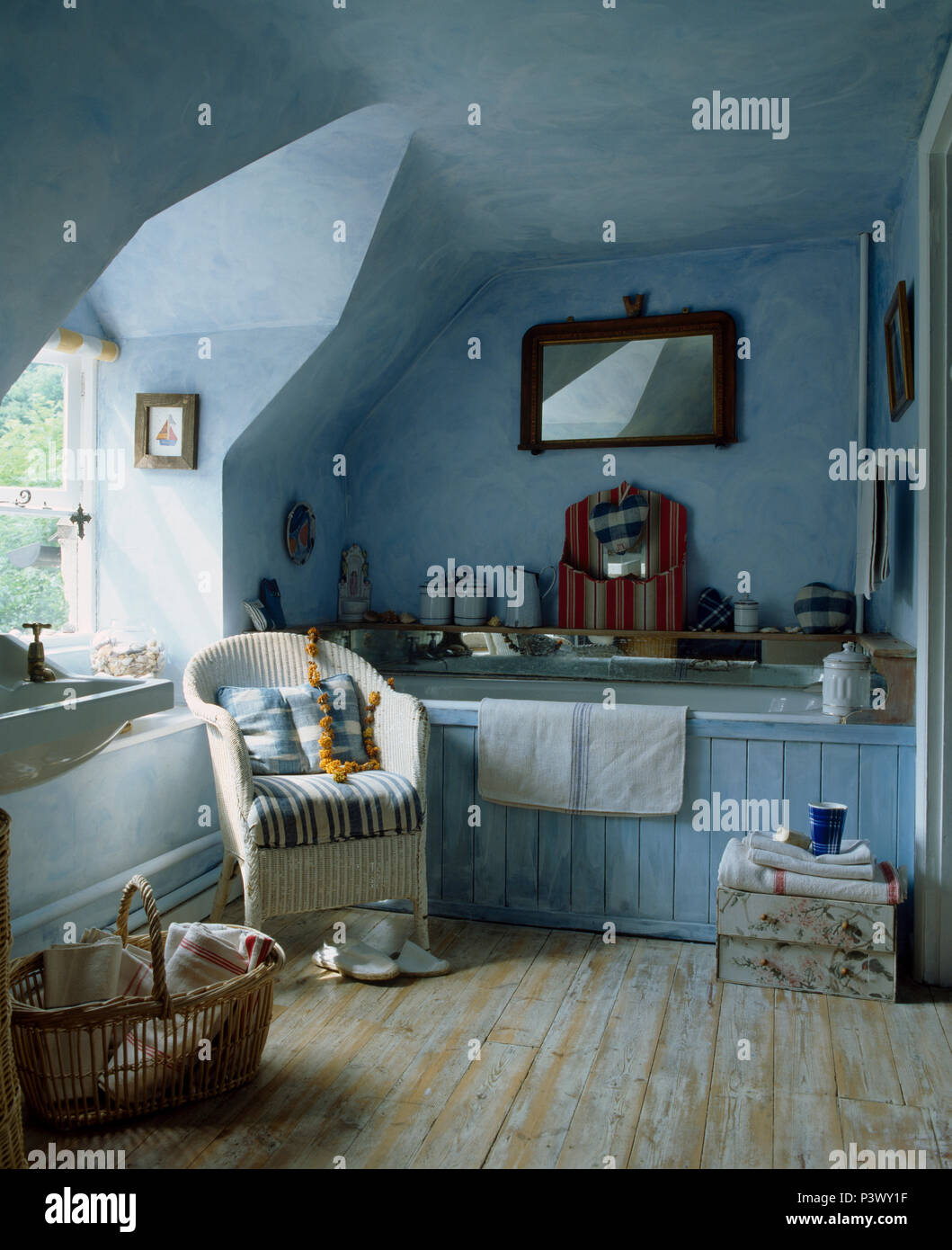 Vecchio stile attico blu bagno con pavimento in pannelli di legno e la sedia di vimini Foto Stock