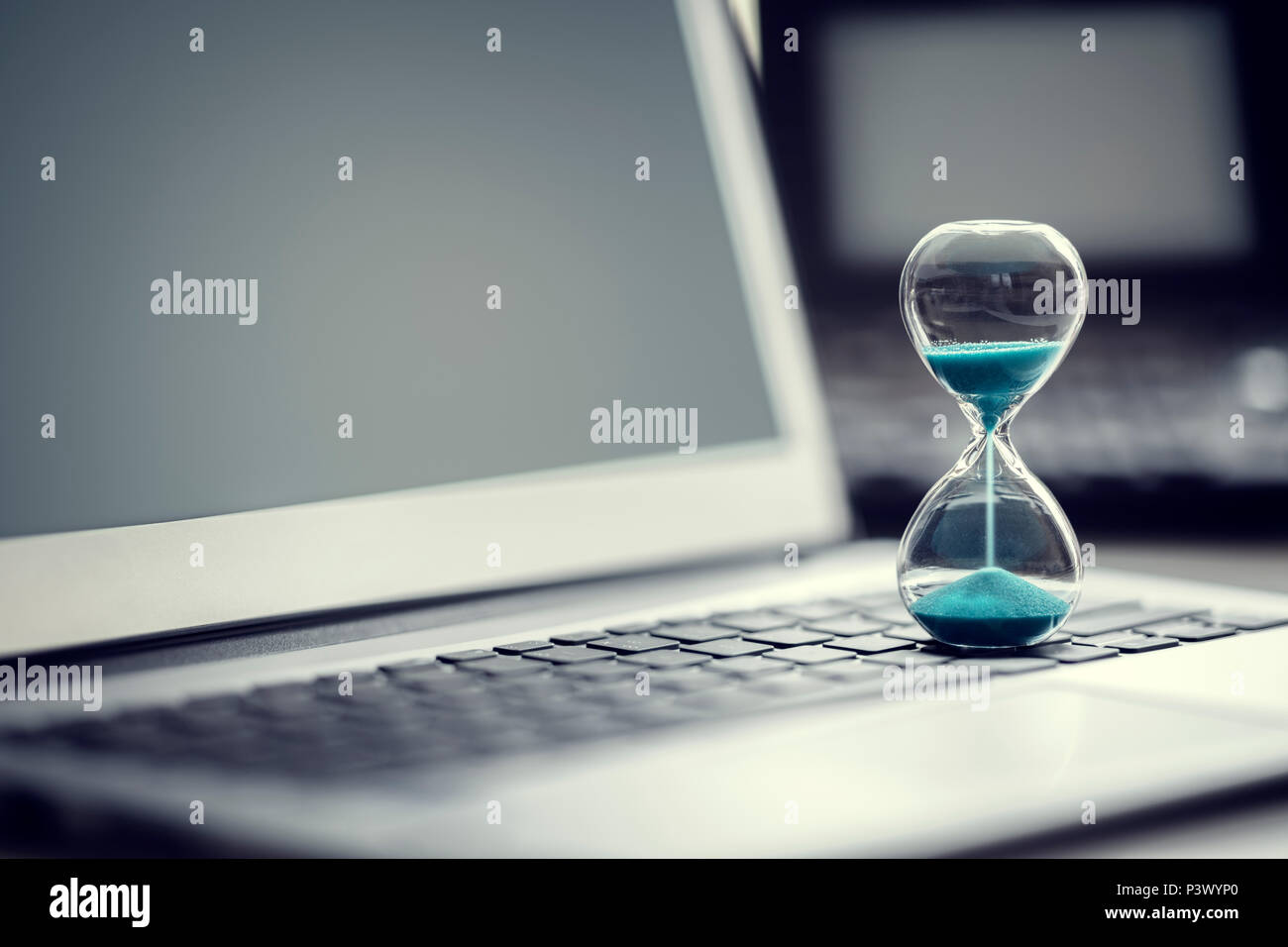 Clessidra sul computer portatile concetto per la gestione del tempo e il conto alla rovescia per la scadenza Foto Stock