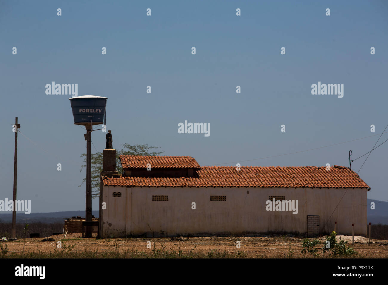 Imagem de Padre Cícero é vista embaixo de uma Caixa d'Água, em uma casa do sertão de Juazeiro do Norte, Ceará. Foto Stock