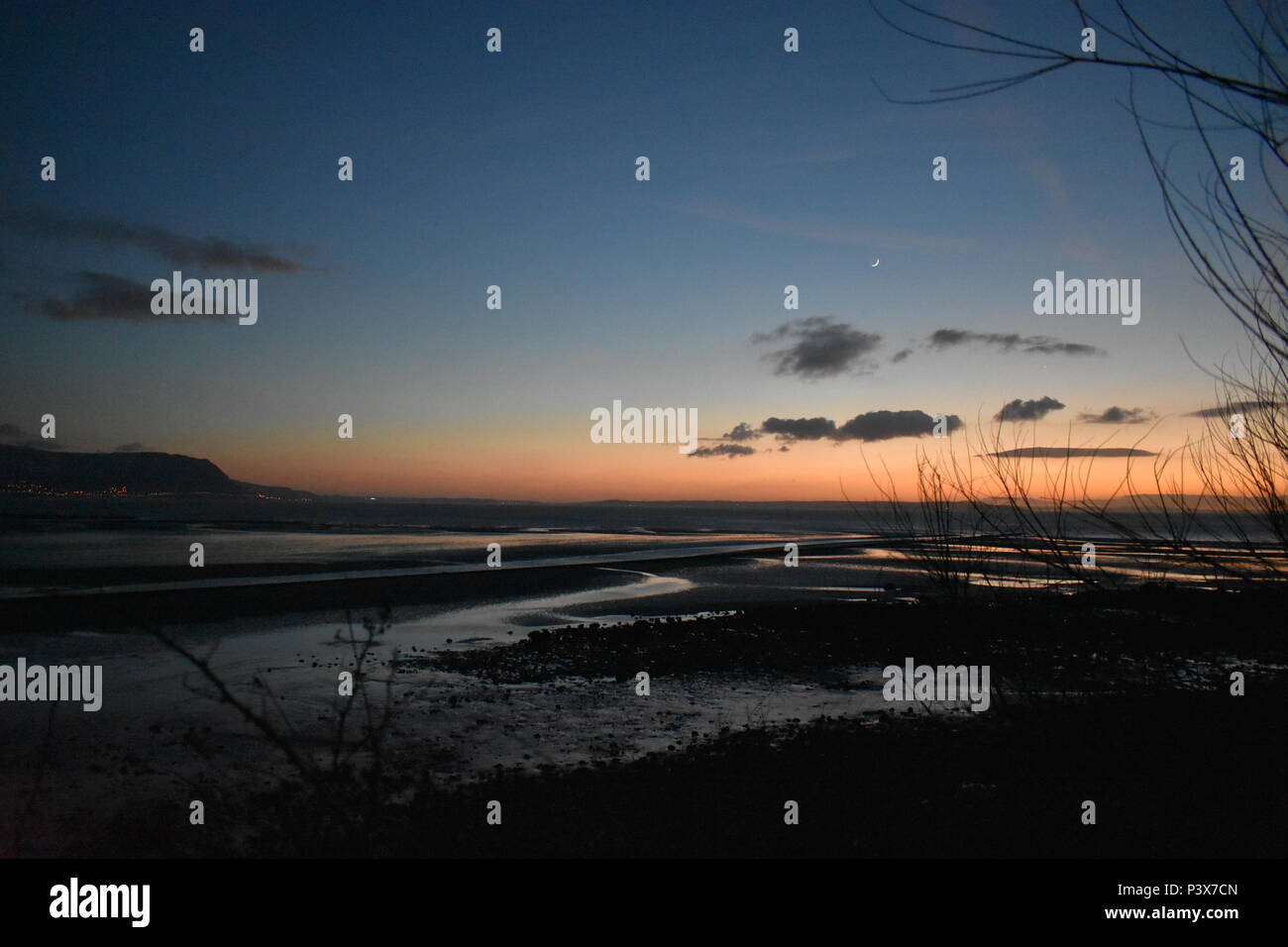 West shore, Llandudno, Galles del Nord, Regno Unito - tramonto invernale, vista di Anglesey sullo sfondo Foto Stock