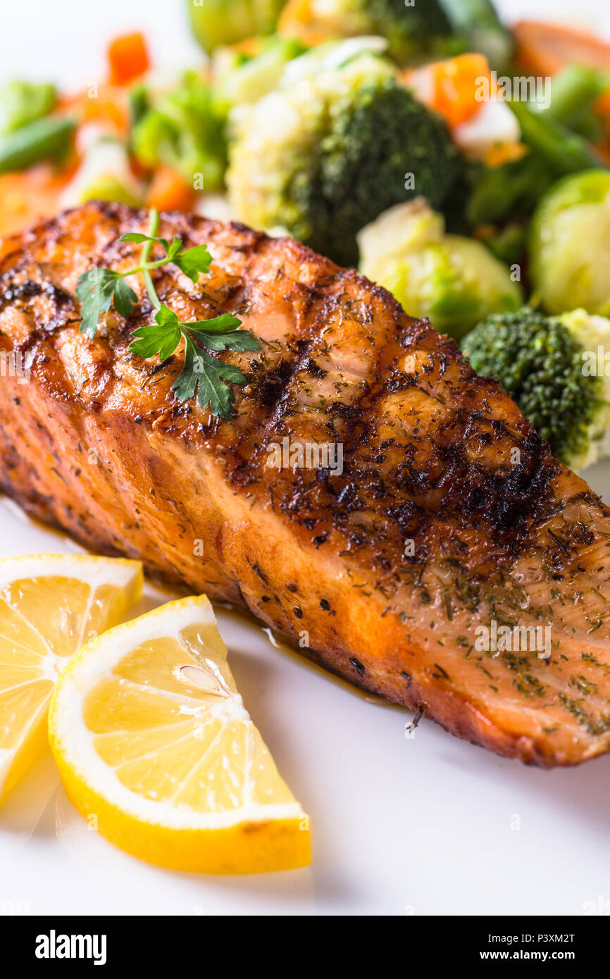 Salmone alla griglia filetto di pesce con verdure mix su piastra bianca. Close up. Foto Stock