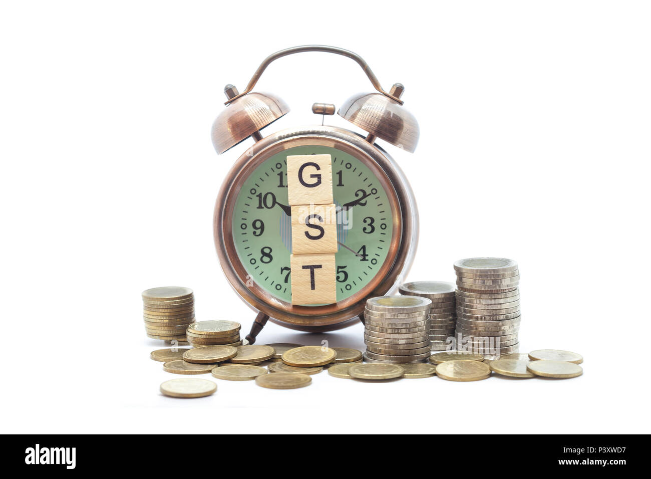Beni e servizi fiscali sulla parola sveglia e pile di monete sul tavolo bianco, il successo nel business del concetto. Foto Stock