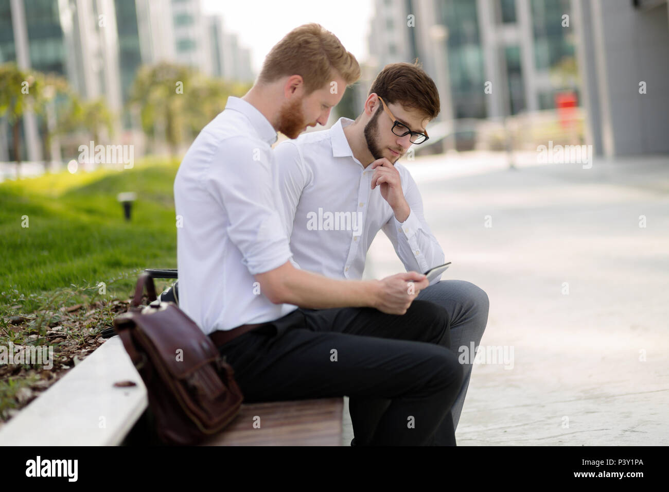 Colleghi di lavoro seduta sul banco di lavoro Foto Stock