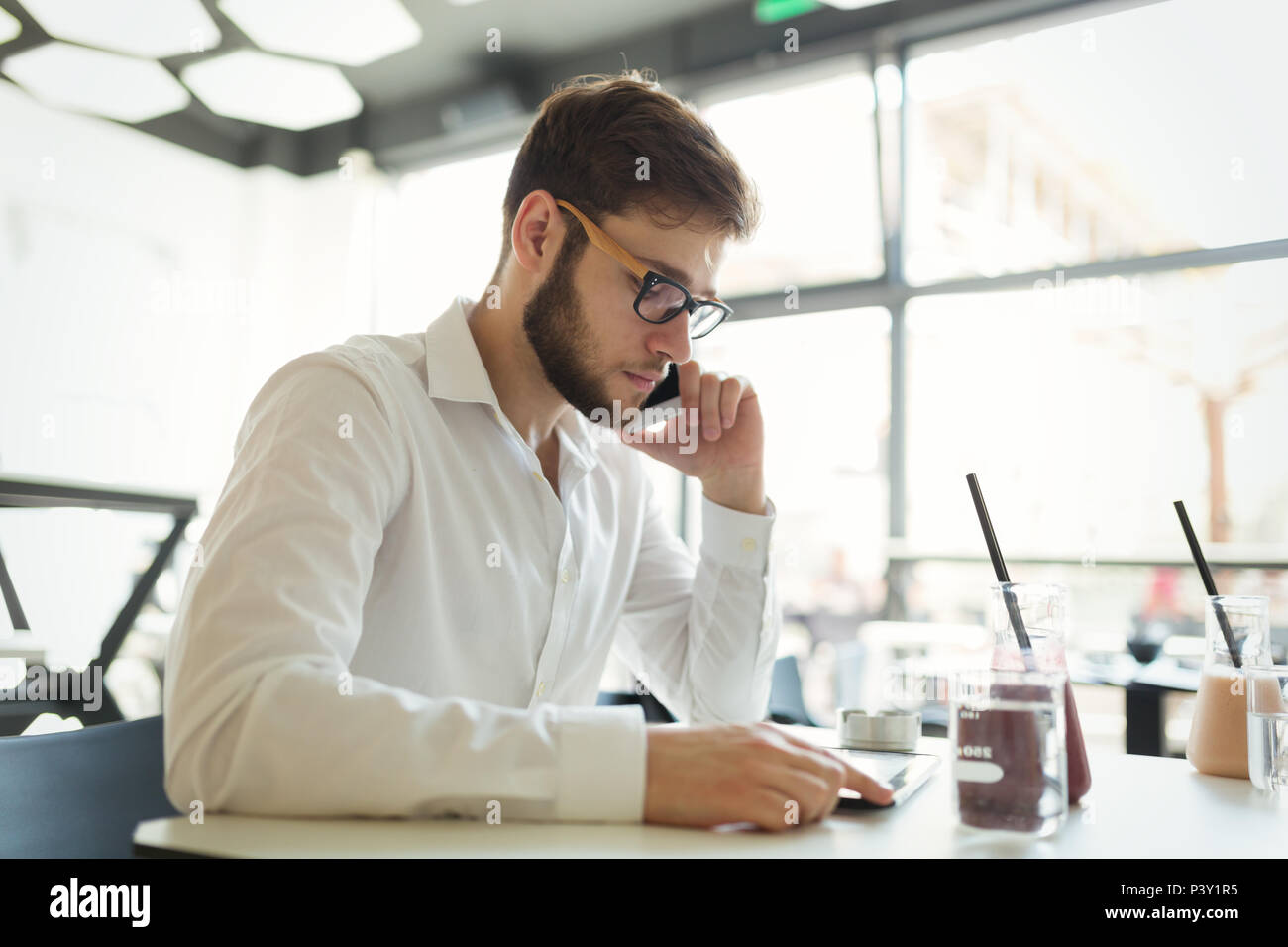 Fiducioso imprenditore occupato lavorando su tablet Foto Stock