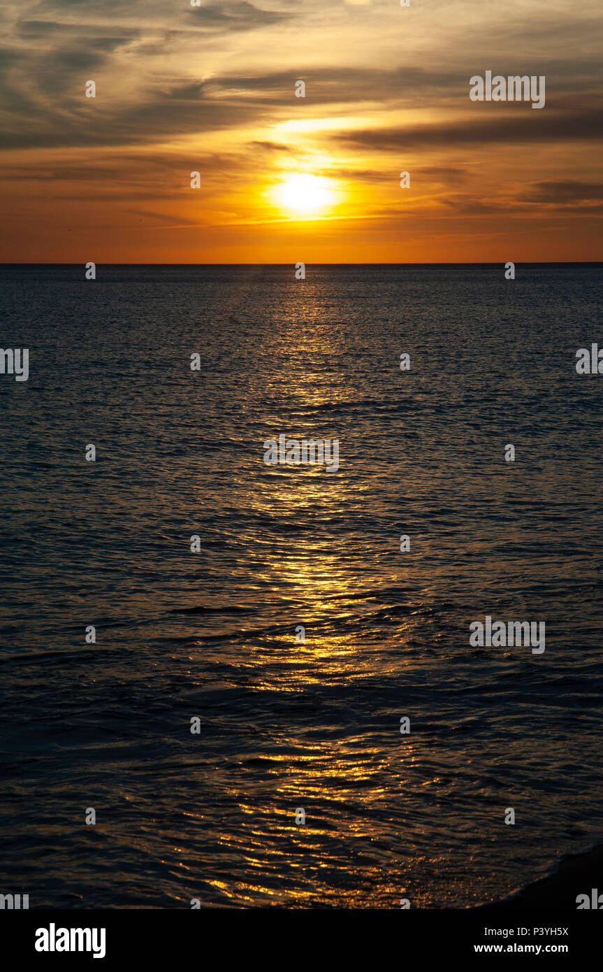 Tramonto sull'oceano con caldi toni di rosso Foto Stock