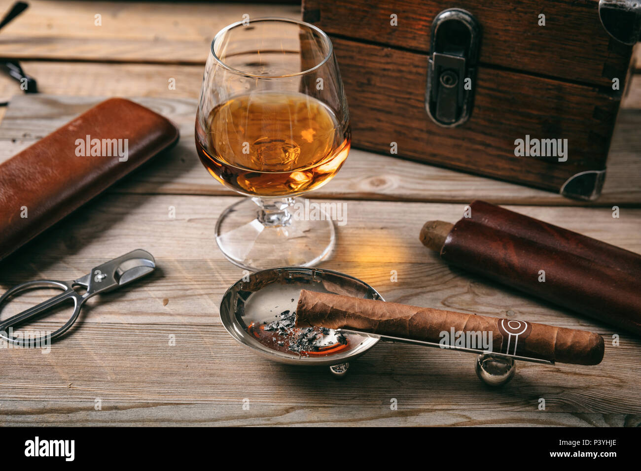 Sigaro cubano e un bicchiere di brandy Cognac su sfondo di legno, primo piano Foto Stock