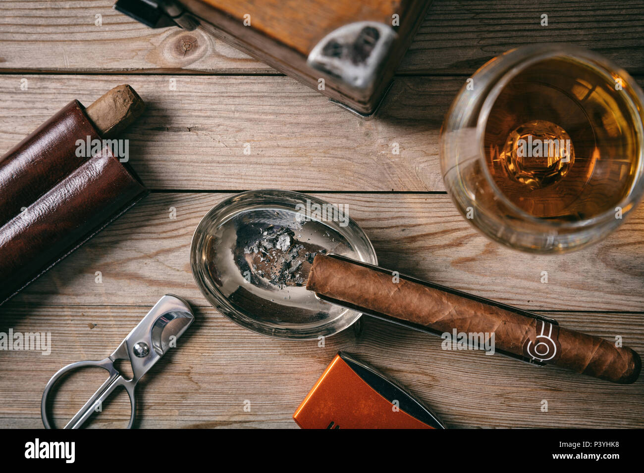Sigaro cubano e un bicchiere di brandy Cognac su sfondo di legno, alto vista ingrandita Foto Stock
