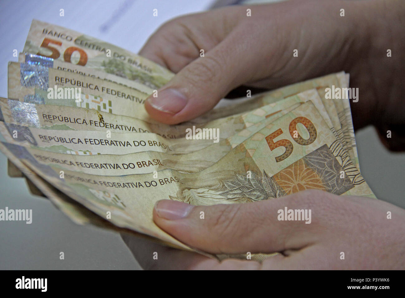 Dinheiro do Brasil, notas de Real, moeda brasileira. Na foto, mãos manipulando notas de 50 reais. Foto Stock