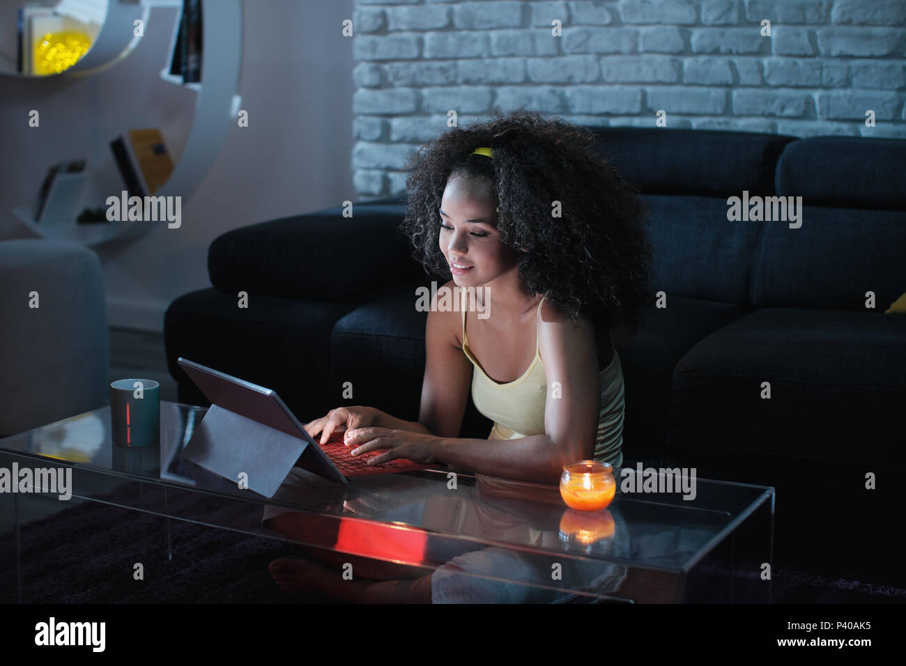 Giovane Latina donna digitando messaggio sul computer portatile di notte Foto Stock