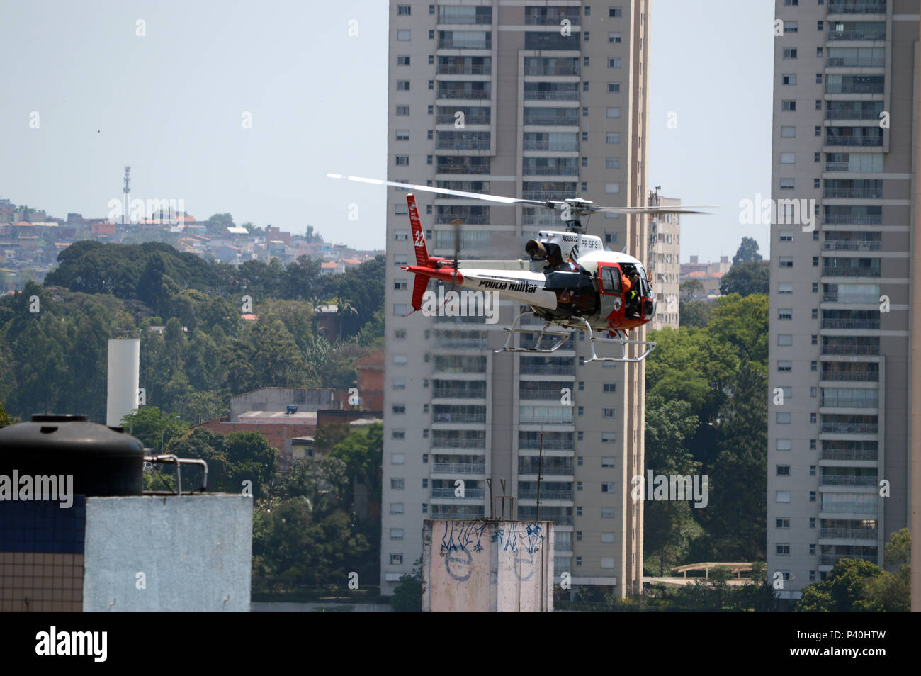 Segurança Pública. Policial a bordo fare helicóptero Águia da Polícia Militar PM de São Paulo sobrevoa bairro na zona Oeste. Foto Stock