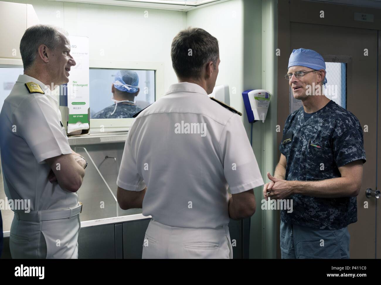 Fotografia di tre ufficiali di marina, indossando uno scrub chirurgico, parlando con ogni altro a bordo della nave ospedale USNS Misericordia, nelle acque al largo di Nha Trang, Vietnam, 23 maggio 2018. () Foto Stock