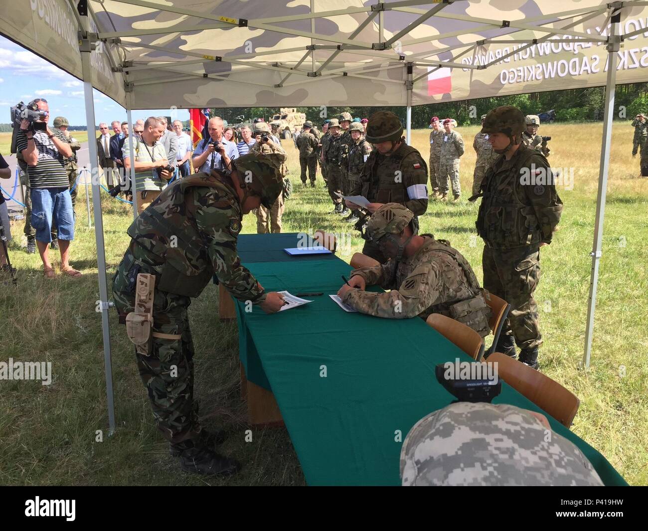 Stati Uniti Esercito Col. Phil Brooks, seduto, comandante della 1° Brigata corazzate contro la squadra, 3d Divisione di Fanteria, Fort Stewart, Ga., segni di un trasferimento di autorità in accordo nel corso di una cerimonia di apertura per esercitare Anakonda 2016 a Drawsko Pomorskie Area Formazione, Polonia, 6 giugno. Esercizio Anakonda 2016 è un polacco-led, multinazionale comune esercizio svolge in tutta la Polonia Giugno 7-17. L'esercizio comporta circa 31.000 partecipanti provenienti da più di 20 nazioni. Esercizio Anakonda 2016 è il principale evento di formazione per gli Stati Uniti Esercito e l'Europa delle nazioni partecipanti e dimostra il regno sta Foto Stock