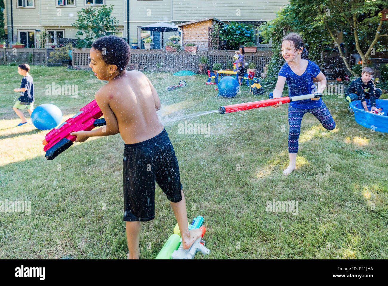 Mantenere fresca e divertimento estivo,. I ragazzi hanno friendly backyard acqua lotta. Foto Stock