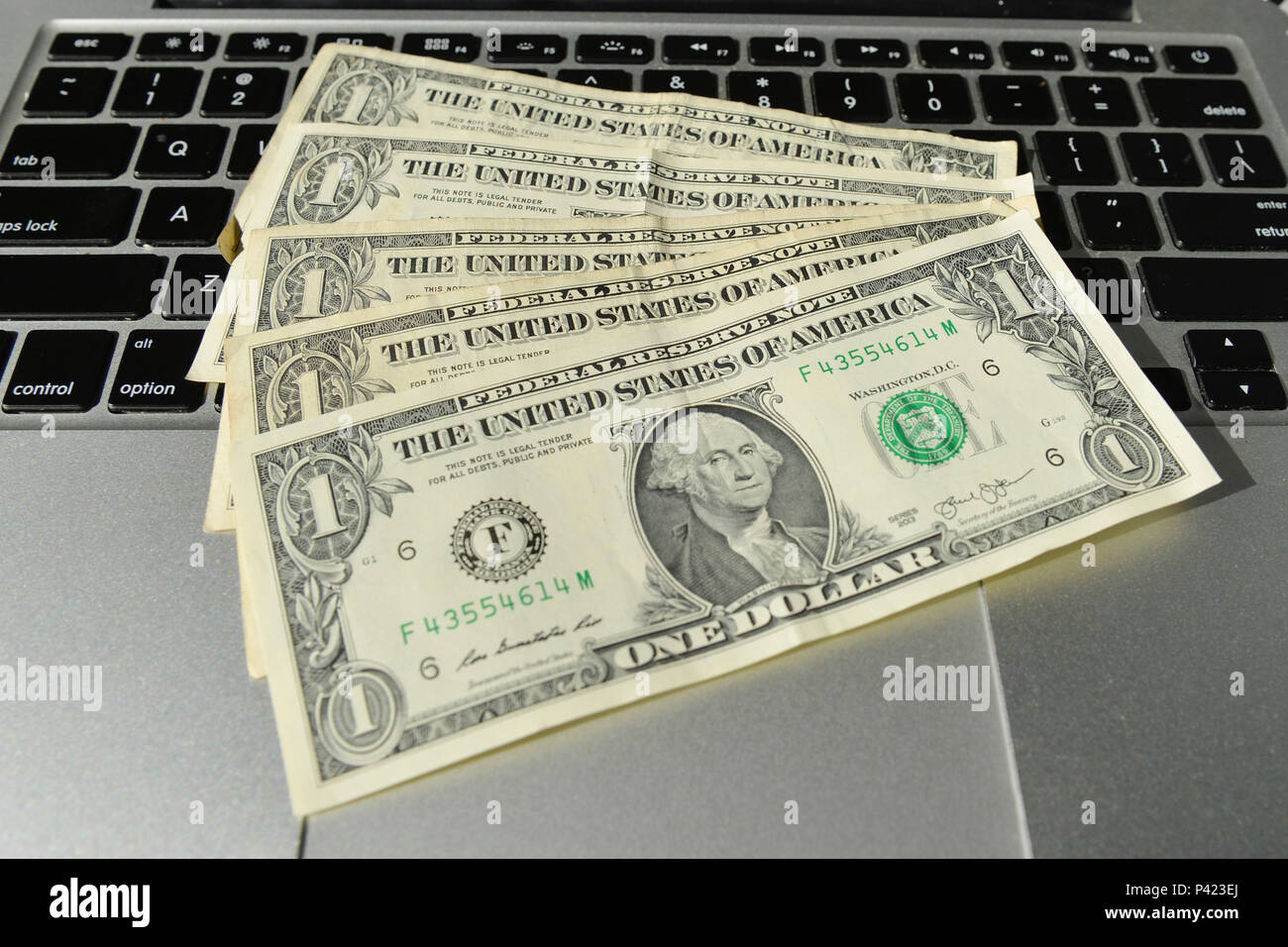Cédulas de 1 dolar sobre teclado de notebook. Foto Stock