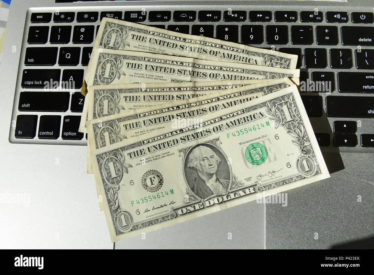 Cédulas de 1 dólar sobre teclado de notebook. Foto Stock