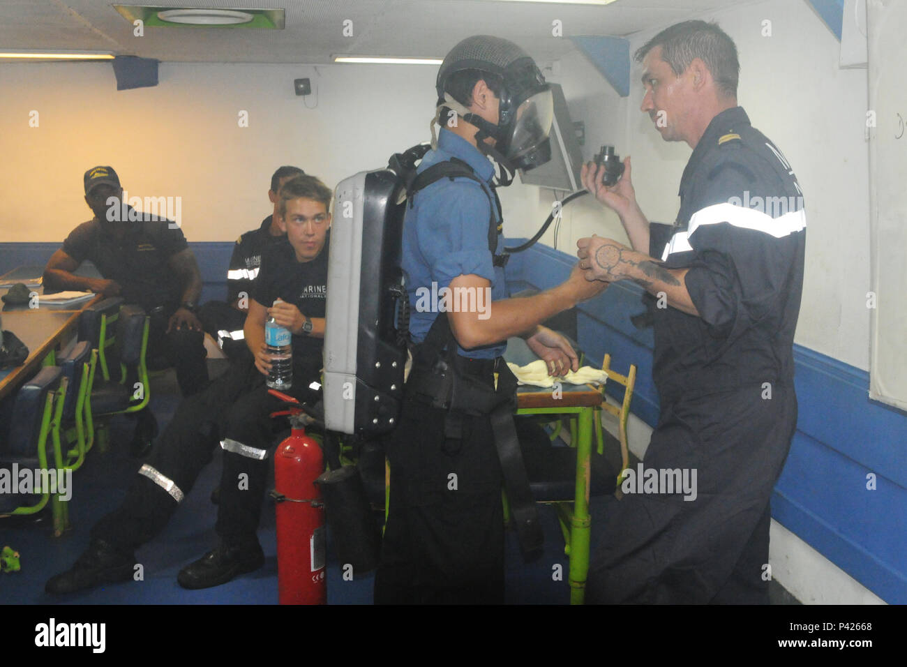 Mortiner Carpentier, un vigile del fuoco con le forze armate francesi, dimostra per i membri delle forze armate canadesi e Barbados Defence Force il metodo giusto per incendio indossare indumenti di protezione durante un esercizio di formazione come parte di Tradewinds 2016 il 6 giugno a Grenada. Questa manifestazione è parte di un pomeriggio di formazione congiunta esercizio tra il francese canadese e Stati Uniti forze specificamente progettati per spiegare ogni paese la singolare tecnica per combattere il fuoco e il tubo di problemi. Tradewinds 2016 è un comune esercizio combinato condotta in collaborazione con i paesi partner per migliorare la Foto Stock