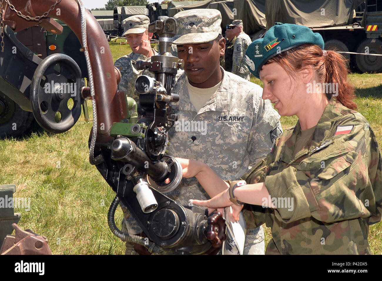 Spc. Donovan Thomas, 5° Battaglione, 113Campo reggimento di artiglieria (High Mobility Artillery Rocket System), North Carolina Esercito Nazionale Guardia, viene insegnato circa il 122 mm WR-40 Langusta semovente per di più un lanciarazzi meccanismo di avvistamento da parte di un soldato polacco durante l'esercizio Anakonda 16 a Jaworze Area Formazione, Polonia, Giugno 5, 2016. Il North Carolina guardie e soldati polacchi appreso ogni altra di artiglieria, veicoli e altre attrezzature durante questa parte dell'esercizio. Un16 è un cittadino polacco di esercizio che cerca di treno, esercizio e integrare nazionale polacca di comando e f Foto Stock
