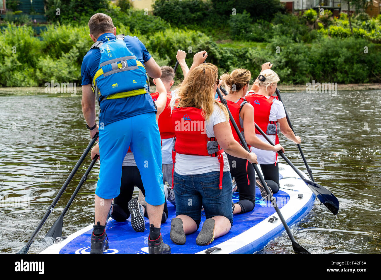 Stand Up Paddle boarding con ispirare a avventura sul fiume Wye a Monmouth. Foto Stock