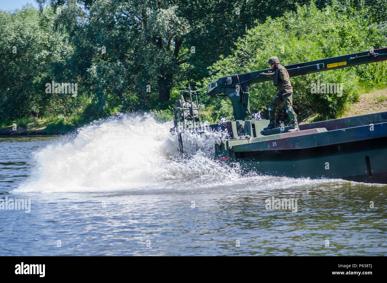 Un soldato tedesco bretelle per impatto come il suo veicolo anfibio entra nel fiume Vistola durante un ponte che attraversa il funzionamento in Chelmno, Polonia, 7 giugno 2016. Forze multinazionali coordinati, assemblato e quindi attraversato un ponte costituito da tedesco e inglese M3 Rig anfibio, permettendo che i veicoli per attraversare il fiume come una parte di esercizio Anakonda 2016. Il polacco-led esercizio è un collettivo sforzo di formazione per rafforzare l'interoperabilità e rafforzare i legami tra gli alleati della NATO e partner, collettivo per garantire la pace e la sicurezza nella regione. Foto Stock
