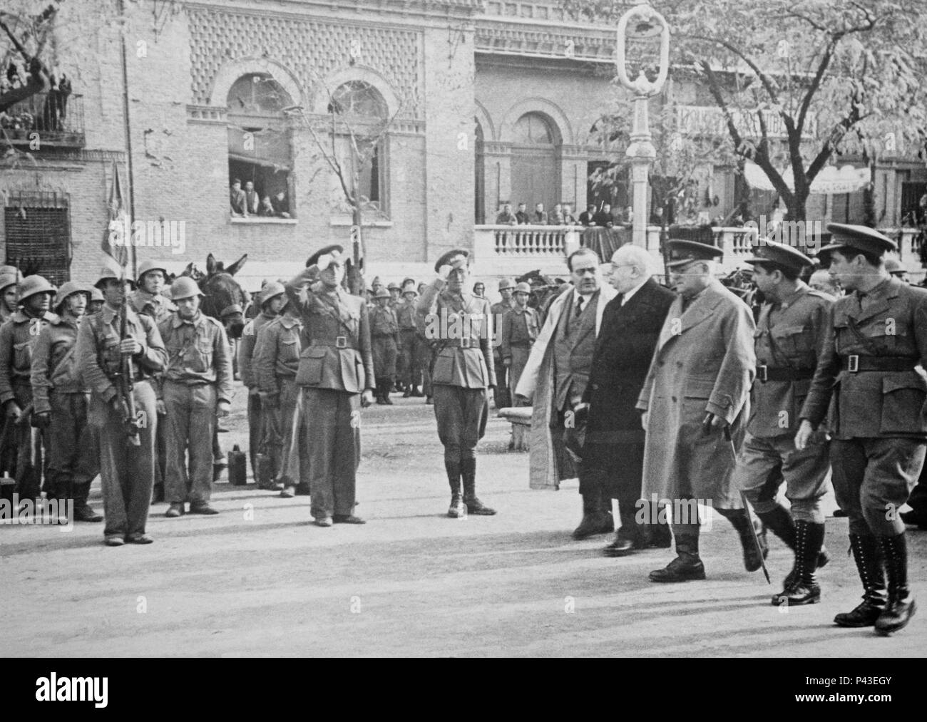 Azaña esamina la divisione 46th dell'esercito popolare nella città di Alcalá de Henares, la città dove nacque Azaña. Egli è accompagnato dal Presidente del Consiglio dei Ministri, Dr. Negín, a sua destra. A sinistra si trova il generale Miaja, capo dell'Esercito del Centro e più a sinistra e con un goatee il comandante della 46th° divisione, maggiore delle milizie, Valentín Gonzalez, noto come 'El Campesino'. La visita fa parte della campagna di visite al fronte e alle unità dell'Esercito popolare da parte del Presidente della Repubblica Foto Stock