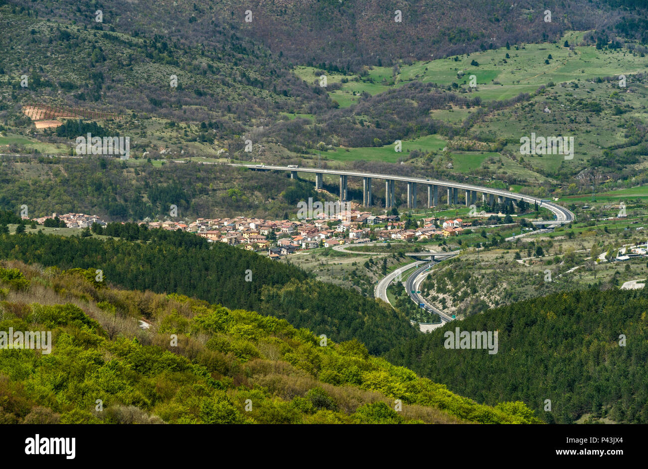 Autostrada A24 sulla città di Assergi, vicino a Galleria del tunnel del Gran Sasso sotto il Corno Grande, massiccio del Gran Sasso Laga National Park, Abruzzo, Italia Foto Stock