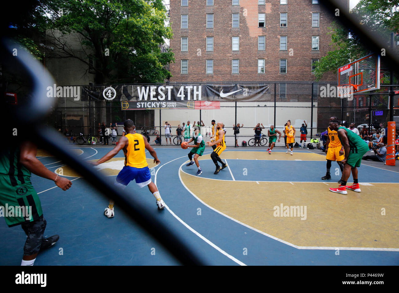 Un torneo di pallacanestro del West 4th con una visione da parte dello spettatore attraverso una recinzione a catena a Greenwich Village, Manhattan, New York, New York. Foto Stock