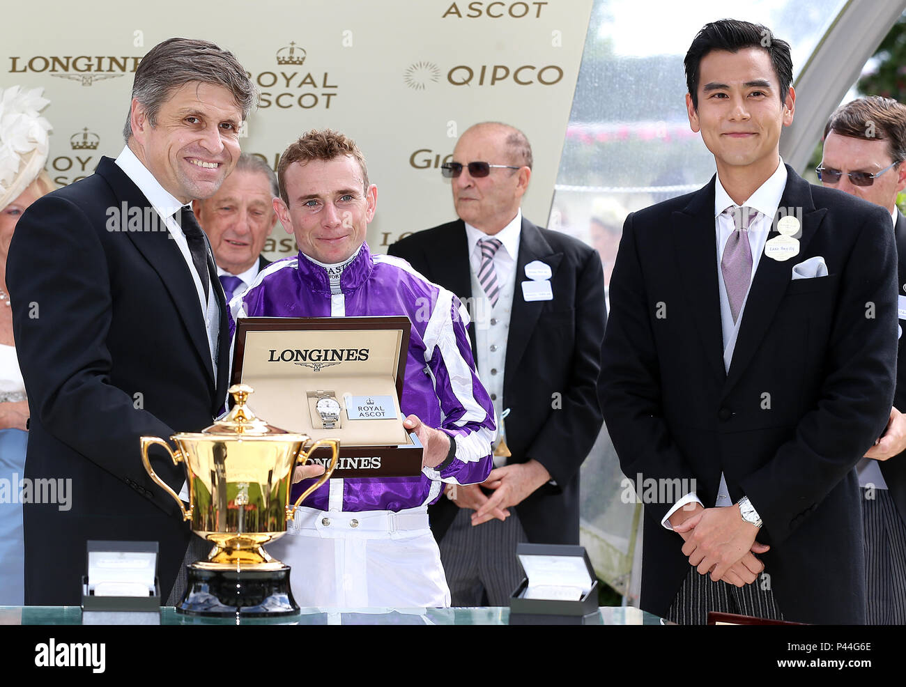 Juan-Carlos Capell (sinistra) e Eddie Peng (destro) presente il premio per la vincita del Queen's vaso jockey Ryan Moore (centro) durante il giorno due di Royal Ascot a Ascot Racecourse. Foto Stock