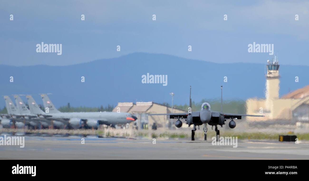 Un U.S. Air Force F-15E Strike Eagle all-weather, estremamente manovrabile e doppio ruolo fighter assegnato alla 494th Fighter Squadron fuori della Royal Air Force Lakenheath, Inghilterra, taxi giù il Eielson Air Force Base in Alaska, linea di volo dopo una fila di parcheggiato Alaska Air National Guard KC-135 Stratotanker rifornimento aeromobili assegnati al 168Air Refuelling Squadron, Giugno 6, 2016 durante la bandiera rossa-Alaska (RF-A) 16-2. RF-A è una serie di Pacific Air Forces commander-campo diretto in esercizi di addestramento per gli Stati Uniti e la nazione partner forze come l'Ala Liberty, consentendo il giunto e unità internazionali per sharp Foto Stock