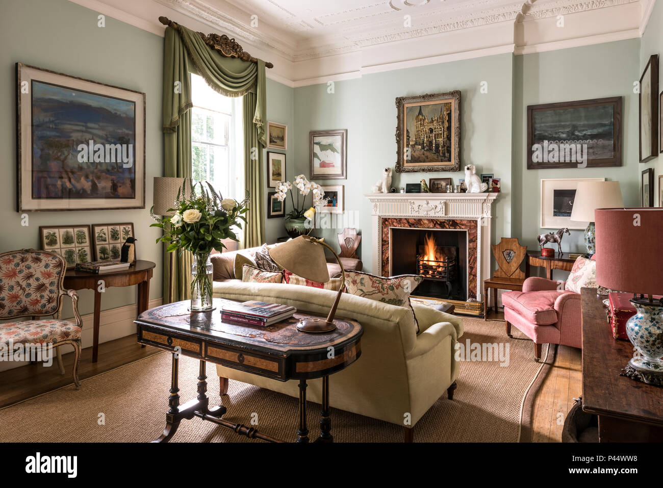 Lampada Vintage sul tavolo verde con le tende e acceso il fuoco Foto Stock