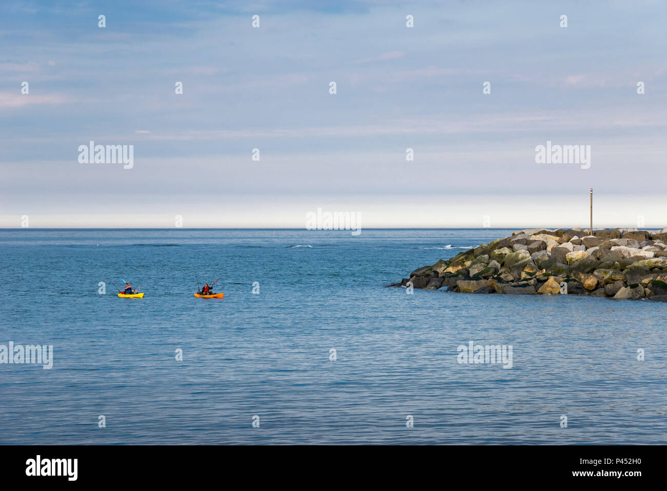 Due kayakers di ritorno da un viaggio di pesca a Staithes, North Yorkshire, Inghilterra. Foto Stock