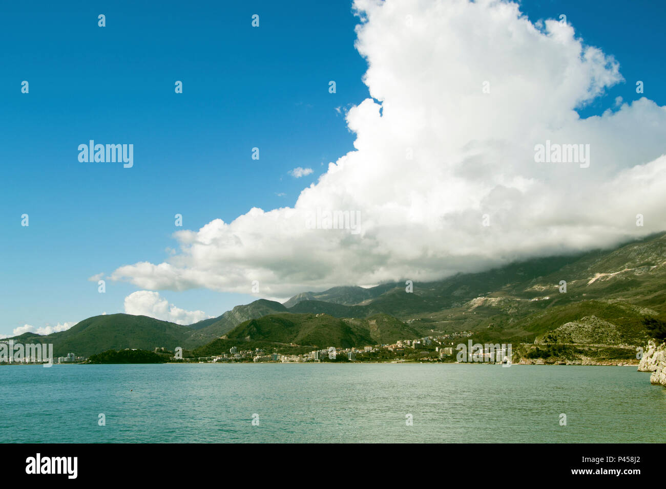 Foto di un paesaggio marino con le montagne e le nuvole all'orizzonte Foto Stock