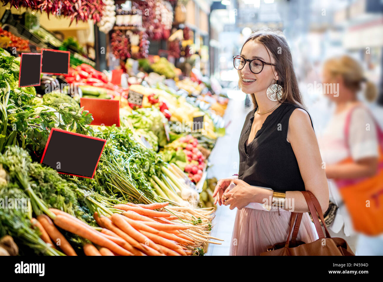 Donna comprare generi alimentari nel mercato Foto Stock